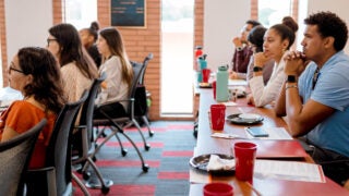 USC students in class with red folders and USC branded red cups.