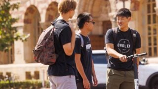 Three students talking near the Marshall School of Business Fertitta Hall.
