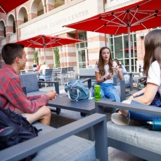 Three students sitting outside eating lunch on a bright Los Angeles Day.