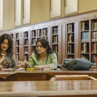 Two students reading together at the library.